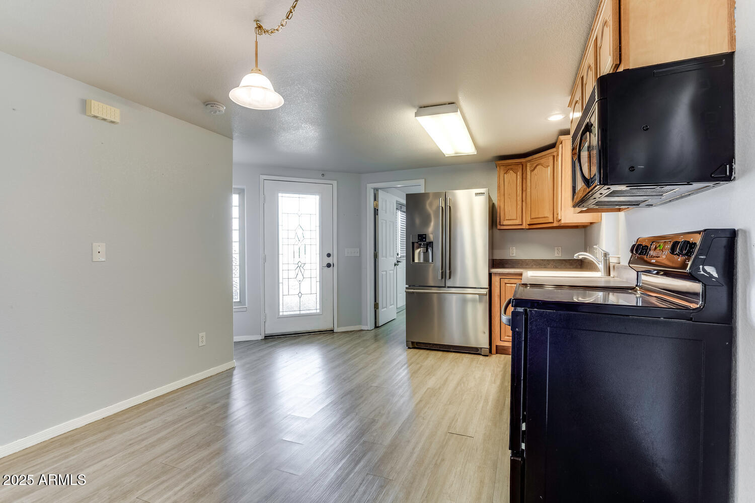 17200 West Bell Road, Unit 1801 Surprise, AZ 85374 - Photo 6 of 40 a kitchen with a refrigerator and a stove top oven