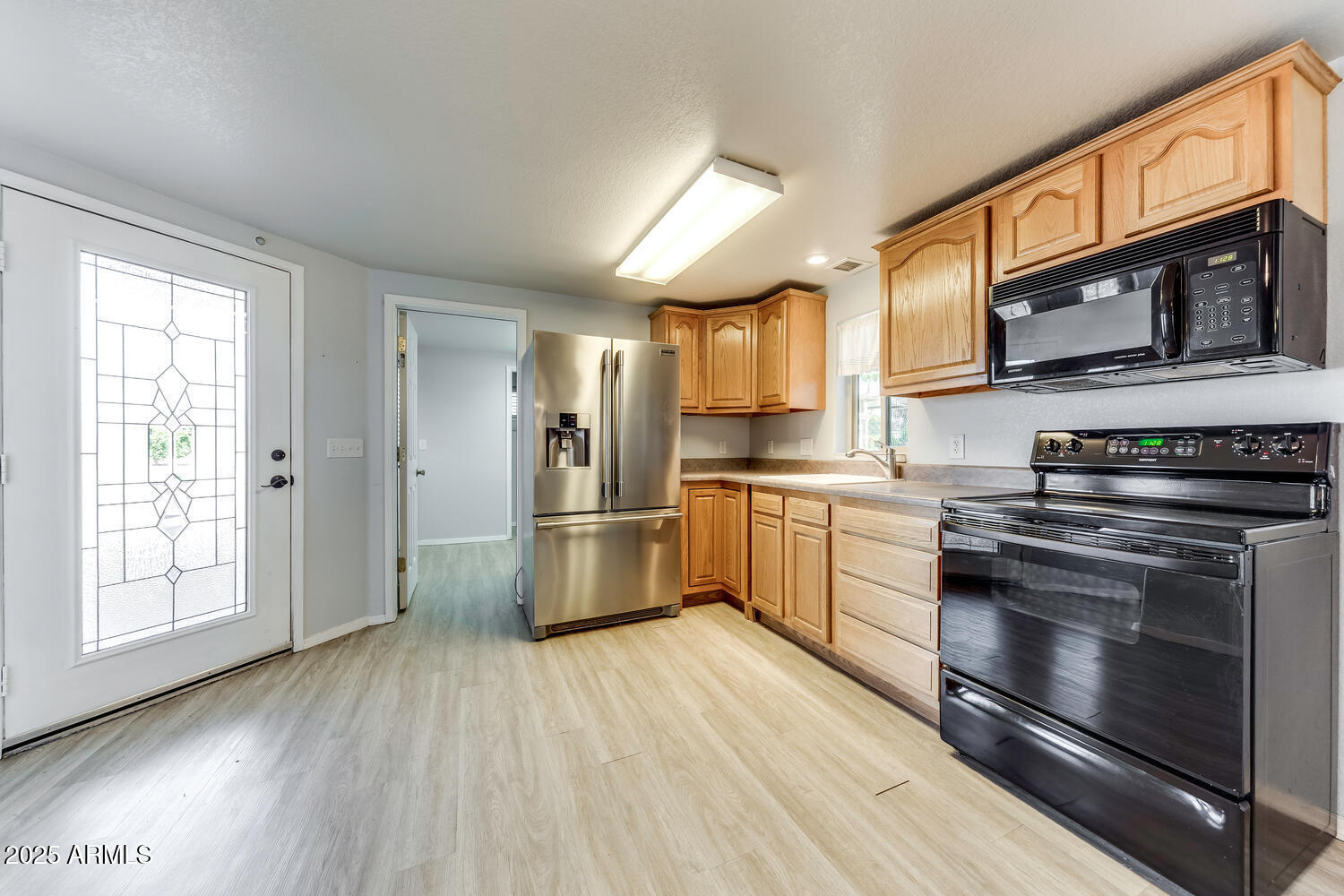 17200 West Bell Road, Unit 1801 Surprise, AZ 85374 - Photo 7 of 40 a kitchen with stainless steel appliances a stove a sink and a refrigerator