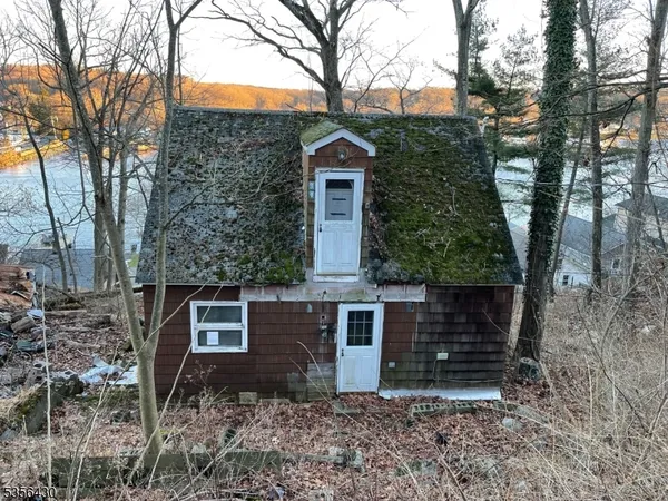 a view of a house with a yard and large tree
