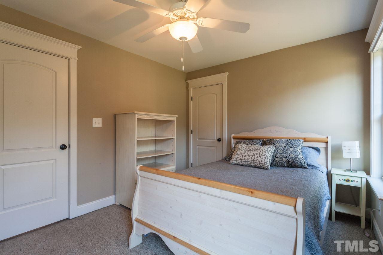 47 High Ridge Court Willow Spring, NC 27592 - Photo 17 of 25 a bedroom with a bed and a chandelier
