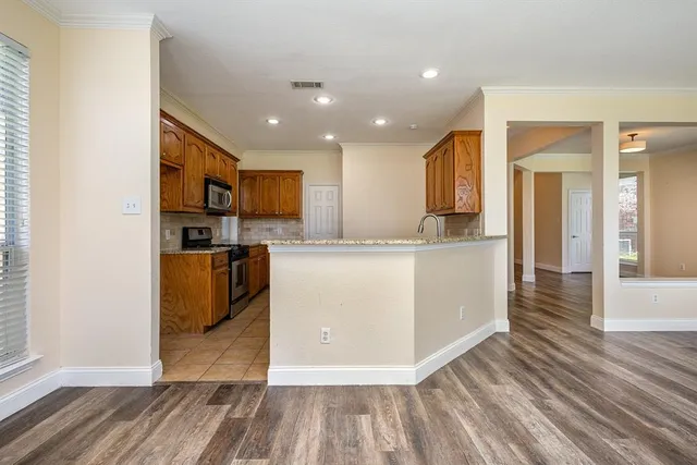 a view of kitchen with cabinets microwave and refrigerator