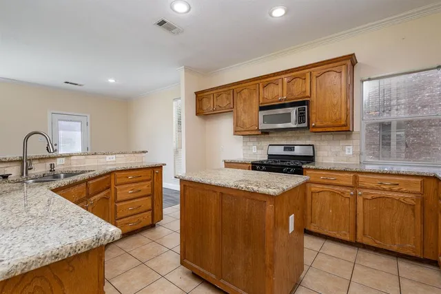 a kitchen with stainless steel appliances granite countertop a sink stove and cabinets