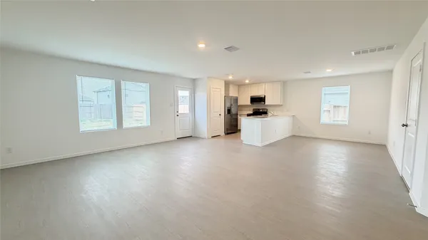 an empty room with a kitchen and stove top oven