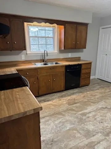 a kitchen with stainless steel appliances granite countertop a sink counter space and a window