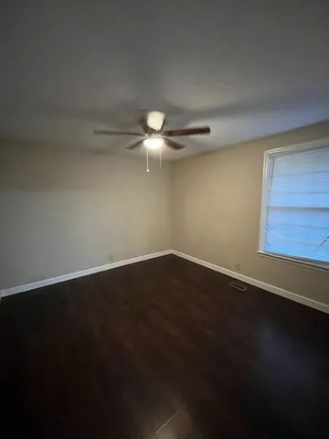 a view of a room with wooden floor and fan
