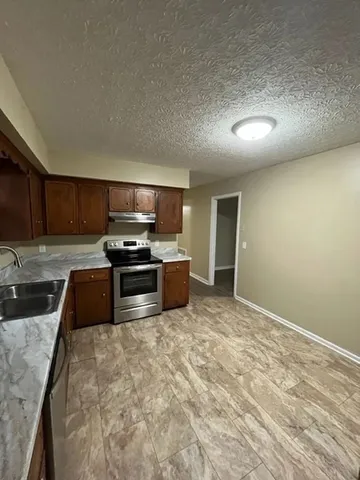 a kitchen with granite countertop a stove and a sink