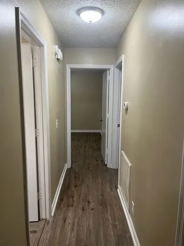 a view of a hallway with wooden floor