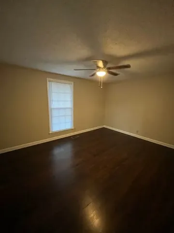 a view of a room with wooden floor and a window