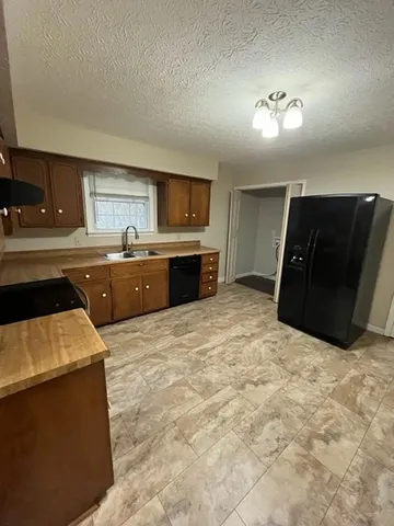 a large kitchen with a stove a sink dishwasher and a refrigerator