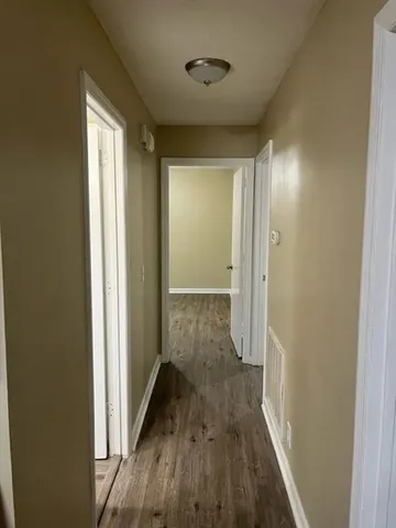 a view of a hallway with wooden floor and closet area