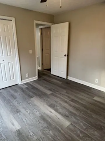 an empty room with wooden floor and mirror