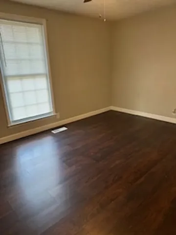 a view of a small space with wooden floor and a window