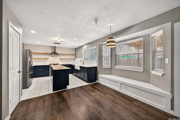 a kitchen with kitchen island a counter top space a sink stainless steel appliances and cabinets