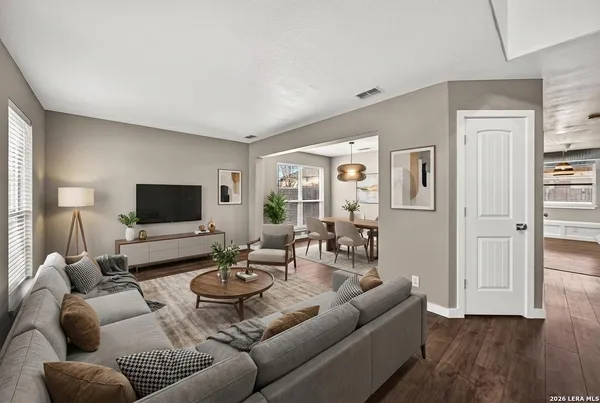 a living room with furniture wooden floor and a flat screen tv