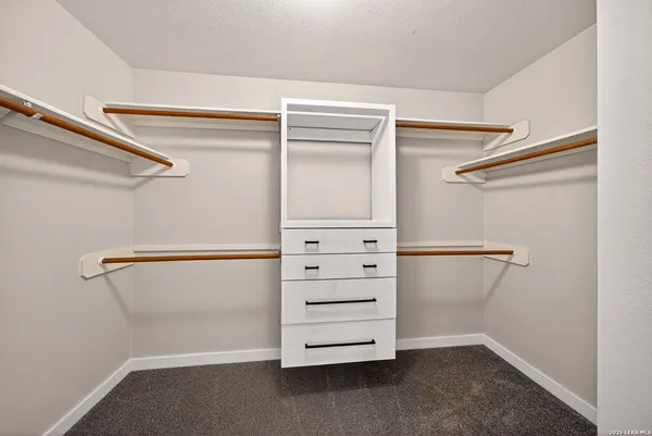 a view of walk in closet with empty racks