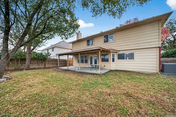 a white house that has a tree in front of it