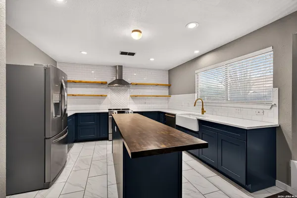 a kitchen with stainless steel appliances cabinets a sink and a refrigerator