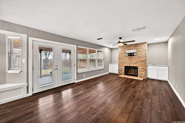 a view of empty room with wooden floor and fireplace