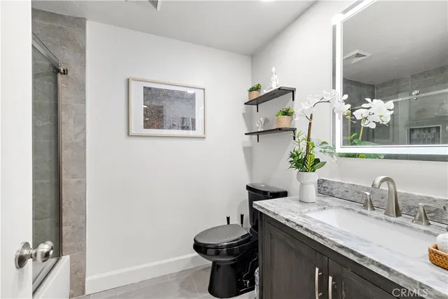 a bathroom with a granite countertop sink a toilet and a mirror