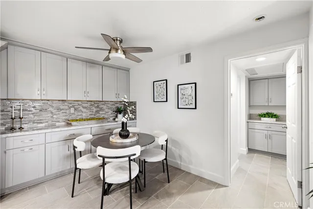 a kitchen with a dining table chairs cabinets and stainless steel appliances