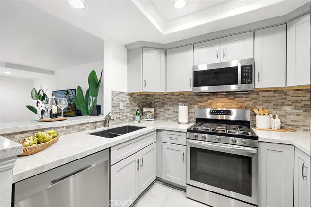 a kitchen with cabinets stainless steel appliances a stove and a window
