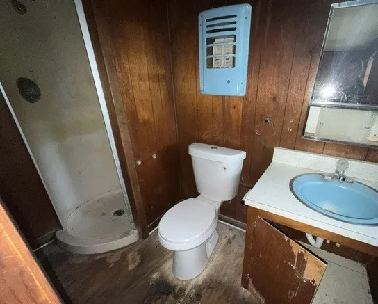 a white toilet sitting next to a bathroom sink and a mirror