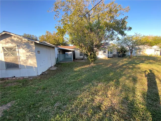 a backyard of a house with table and chairs