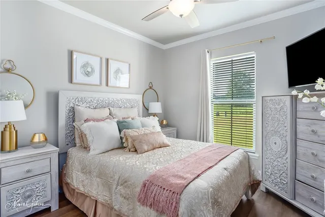 a bedroom with a bed and a flat tv screen on dresser