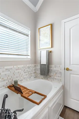 a bathroom with a tub sink and a window