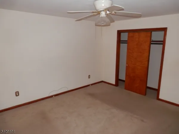 an empty room with a ceiling fan and a window