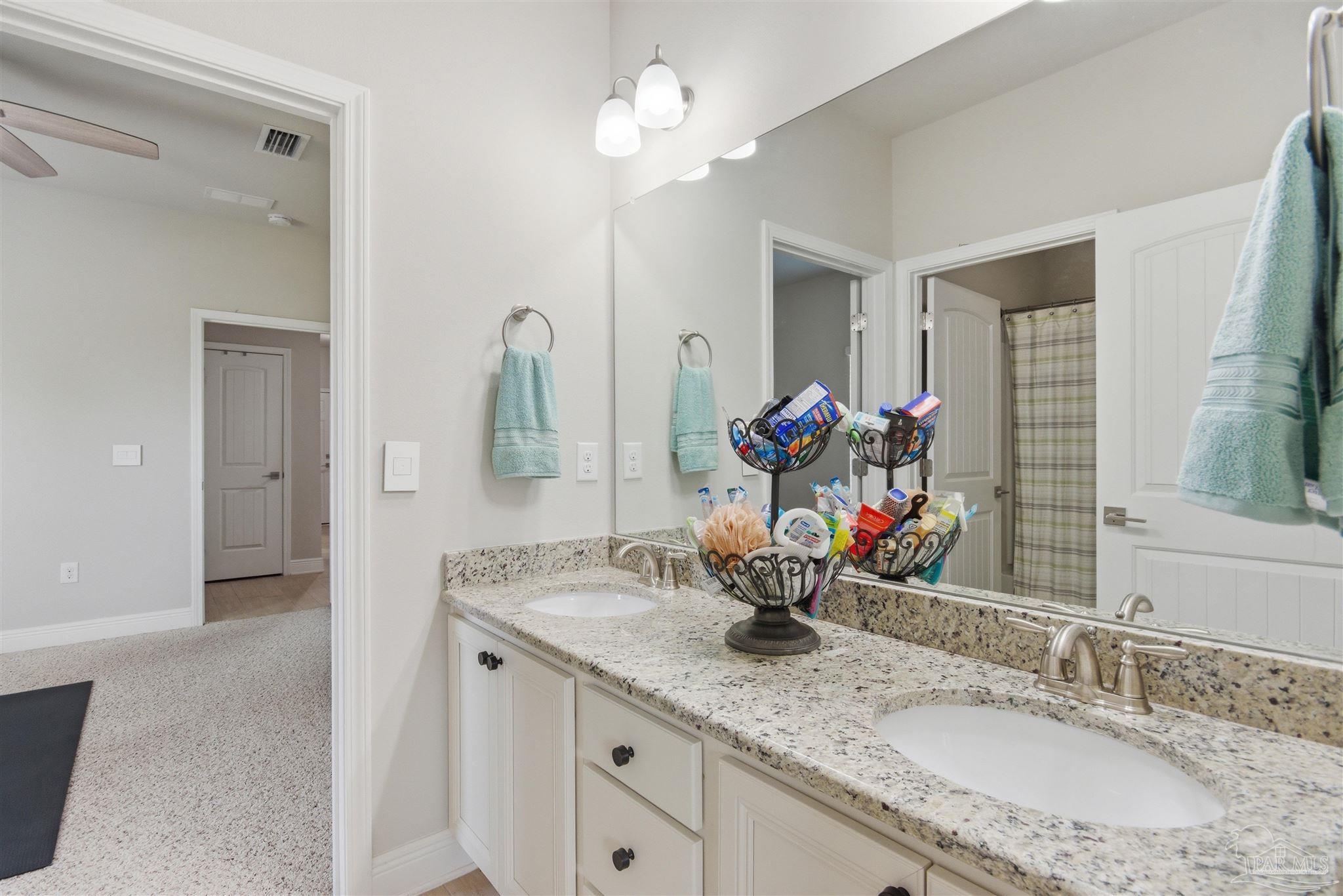 2677 Tulip Hill Road Pace, FL 32571 - Photo 26 of 35 a bathroom with a granite countertop sink a large mirror and a window