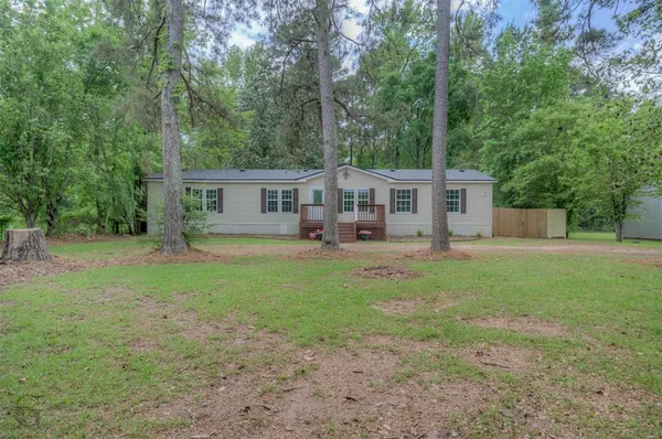 a view of a house with backyard and a tree