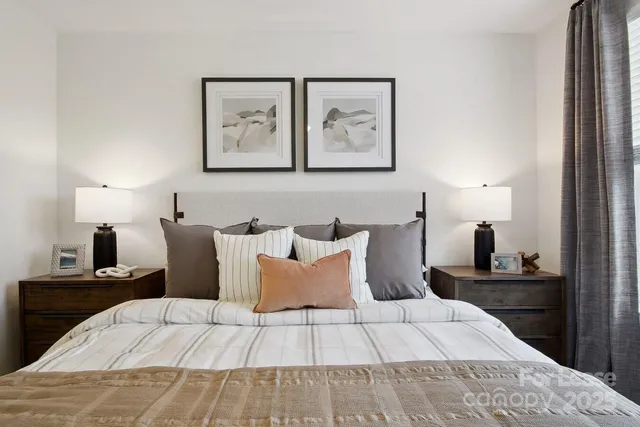 a bed room with a bed and painting on the wall