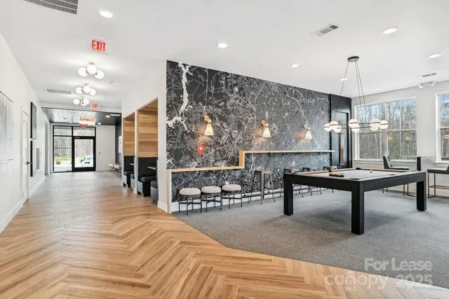 a living room with furniture a rug and potted plants