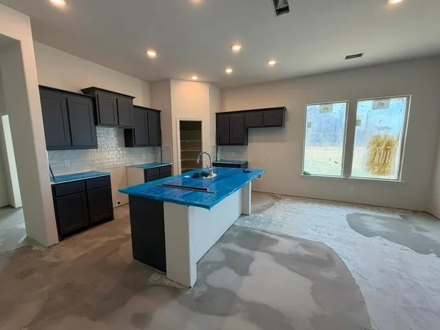 a kitchen with stainless steel appliances granite countertop a stove refrigerator sink and microwave