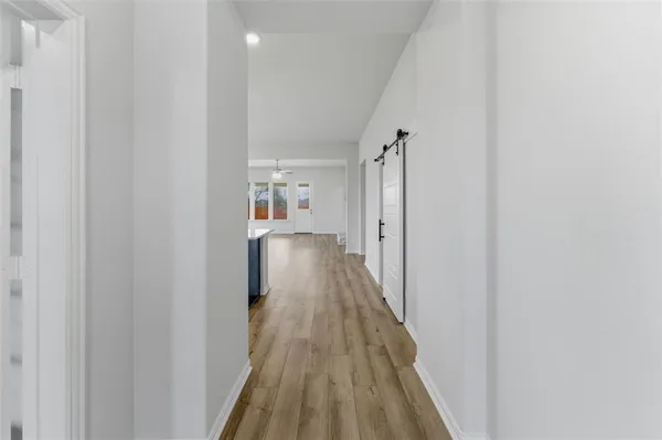 a view of a hallway with wooden floor and staircase