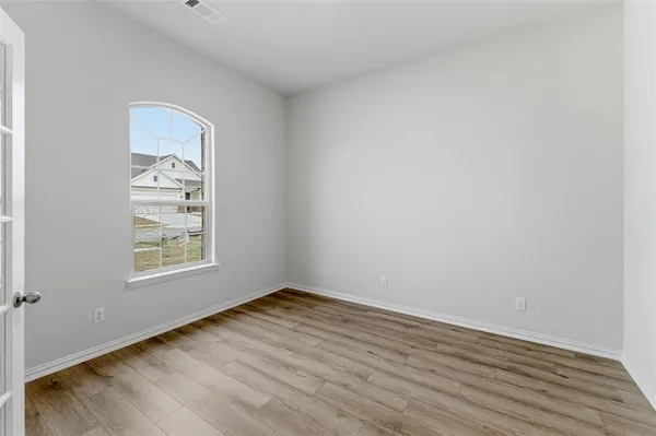 a view of a small space with wooden floor and a window