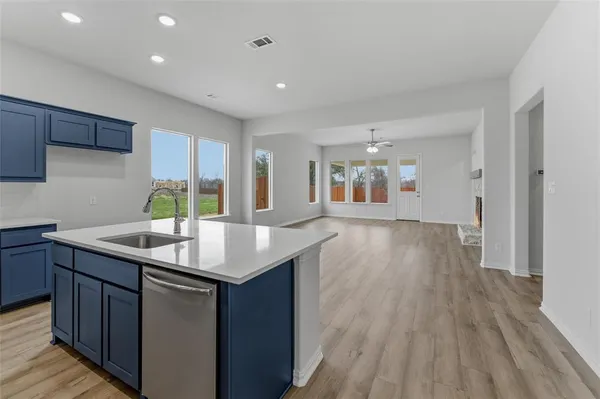 a kitchen with stainless steel appliances granite countertop a sink dishwasher and a stove with wooden floor