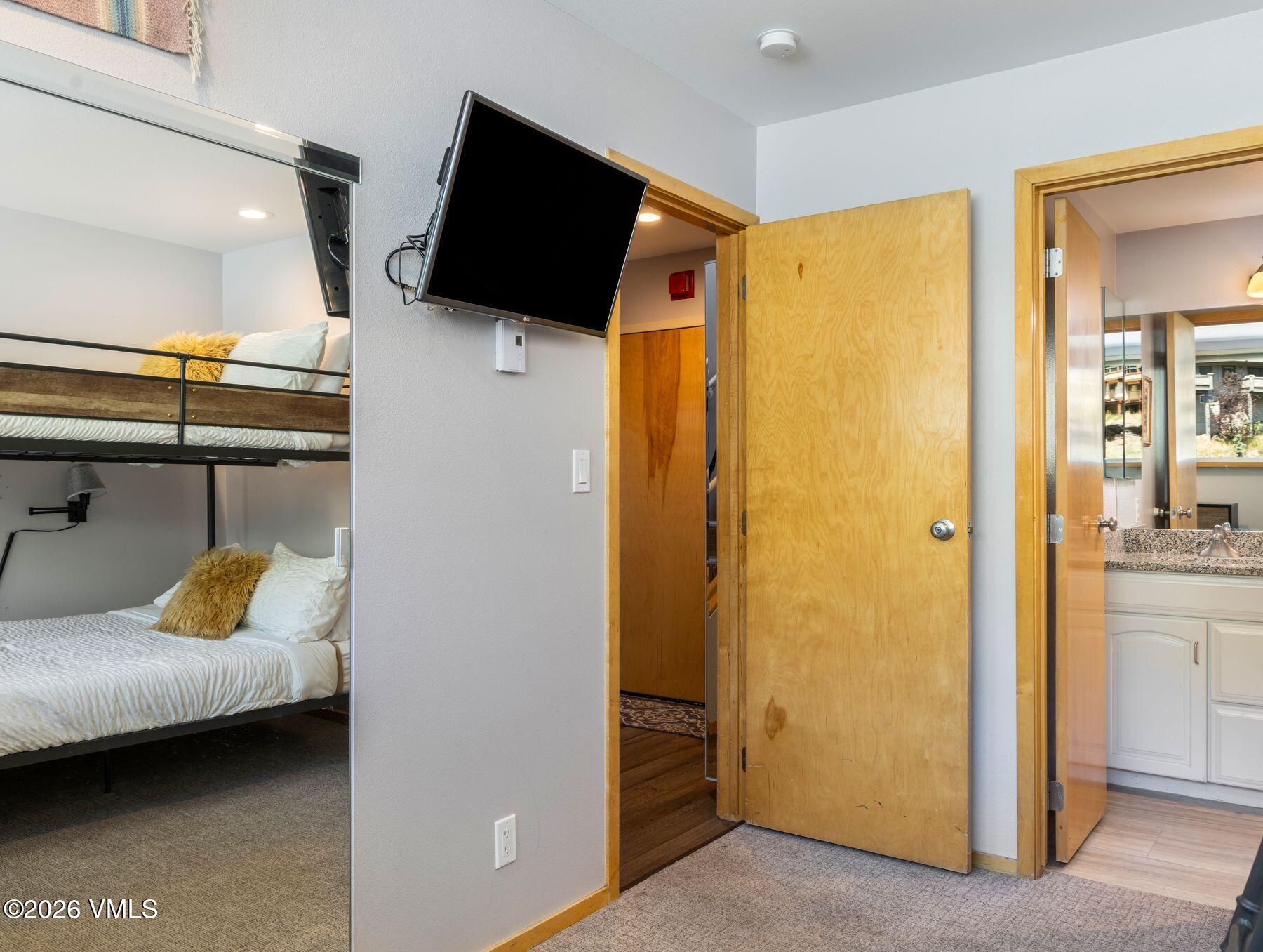 1100 North Frontage Road West, Unit 1503 Vail, CO 81657 - Photo 21 of 32 a bedroom with a bed and flat screen tv