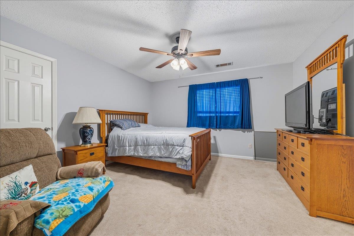 6870 Deerfield Road Bartlett, TN 38135 - Photo 16 of 28 Bedroom with a textured ceiling, light colored carpet, and a ceiling fan