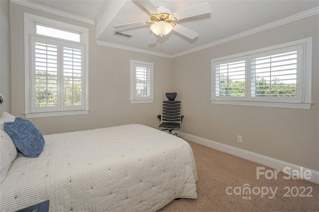 20025 North Cove Road Cornelius, NC 28031 - Photo 36 of 45 a bedroom with a bed and a chandelier