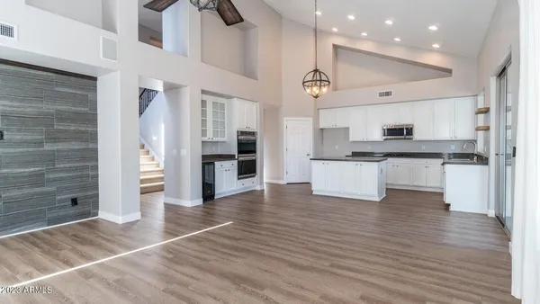 a view of kitchen with cabinets stainless steel appliances and wooden floor
