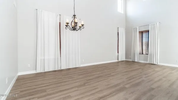 a view of a room with wooden floor and chandelier