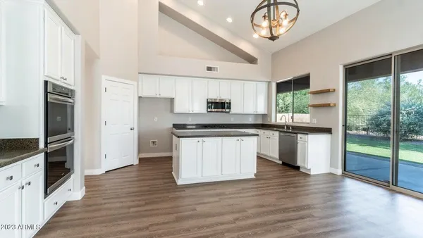 a kitchen with granite countertop a refrigerator and a stove top oven