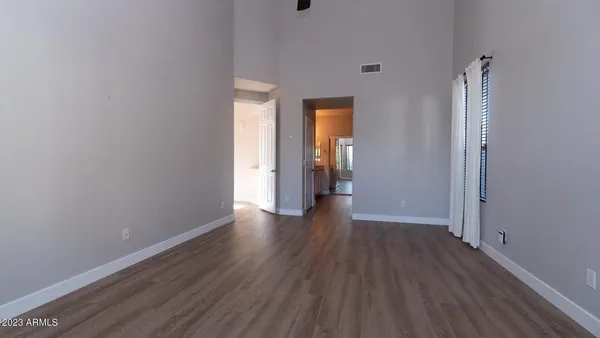 a view of an empty room with wooden floor and closet