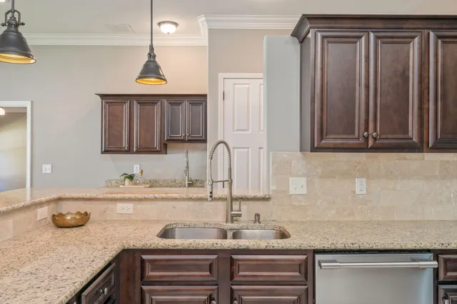 a kitchen with granite countertop a sink and a wooden cabinets