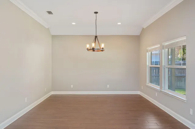 a view of a room with wooden floor and windows
