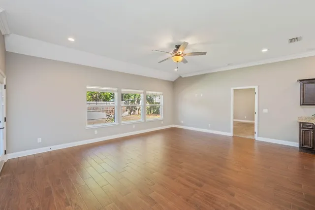an empty room with wooden floor and window