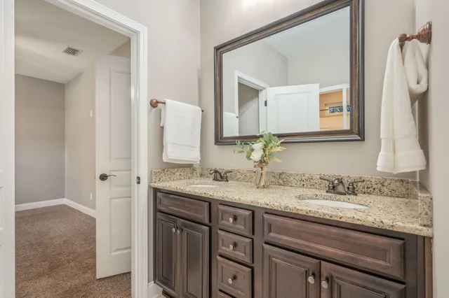 a bathroom with a granite countertop sink and a mirror
