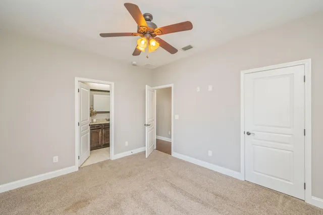 an empty room with closet and a ceiling fan